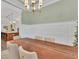 Elegant dining room featuring a modern chandelier, wainscoting and a large wooden table with seating for six at 6600 Horned Owl Pl, Sarasota, FL 34241