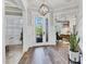 Elegant foyer with decorative light fixture, wood floors, and paneled walls at 6600 Horned Owl Pl, Sarasota, FL 34241