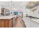 Bright, open kitchen with modern appliances, wooden cabinets, and a large kitchen island overlooking the living area at 6600 Horned Owl Pl, Sarasota, FL 34241