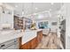 Well-lit kitchen with white cabinetry, marble countertops, and an island with seating at 6600 Horned Owl Pl, Sarasota, FL 34241