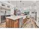 Open concept kitchen with white cabinetry, a large center island, and views of the living room at 6600 Horned Owl Pl, Sarasota, FL 34241