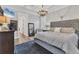 Comfortable main bedroom with a decorative chandelier, a plush rug, and a glimpse into a connected bathroom at 6600 Horned Owl Pl, Sarasota, FL 34241