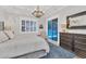 Serene main bedroom featuring a decorative antler chandelier, large windows, and a glimpse of the pool at 6600 Horned Owl Pl, Sarasota, FL 34241