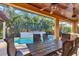 Covered patio with table overlooking a pool with a lush garden backdrop at 6600 Horned Owl Pl, Sarasota, FL 34241