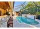 The screened-in pool area has an outdoor bar, a pergola-covered lounge, and a beautiful waterfall feature at 6600 Horned Owl Pl, Sarasota, FL 34241