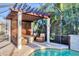 Inviting poolside lounge area with a pergola, perfect for relaxing and enjoying the beautiful outdoor space at 6600 Horned Owl Pl, Sarasota, FL 34241