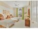 Cozy bedroom with twin beds, ceiling fan, and ample natural light at 7718 Heathfield Ct, University Park, FL 34201