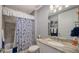 Clean bathroom with a single sink vanity, toilet, and tub/shower combination with a patterned shower curtain at 7910 34Th W Ave # 203, Bradenton, FL 34209