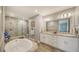 Luxurious bathroom featuring double sinks, a soaking tub, a walk-in shower, and elegant finishes at 7910 34Th W Ave # 203, Bradenton, FL 34209