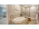 Bright bathroom featuring a soaking tub with tile surround and a glass-enclosed shower at 7910 34Th W Ave # 203, Bradenton, FL 34209