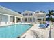 Large community pool surrounded by lounge chairs, umbrellas, and lush tropical landscaping at 7910 34Th W Ave # 203, Bradenton, FL 34209