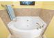 Bright bathroom features a corner bathtub with tiled surround and brushed nickel fixtures at 808 3Rd W Ave # 205, Bradenton, FL 34205