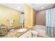 Bathroom featuring granite countertop, tile shower/tub, and decorative mirror at 808 3Rd W Ave # 205, Bradenton, FL 34205