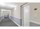 Long hallway with carpet, neutral paint, and white door with unit number at 808 3Rd W Ave # 205, Bradenton, FL 34205