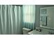 Bright bathroom features white fixtures and a window with sheer blue curtains at 820 Coconut Rd, Venice, FL 34293
