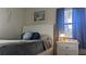 Bright bedroom with a white bed, blue curtains, and beach-themed decor at 820 Coconut Rd, Venice, FL 34293