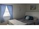 Comfortable bedroom with a white bed, blue curtains, and beach-themed accents at 820 Coconut Rd, Venice, FL 34293