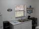 Bright kitchen featuring a stainless steel sink, white cabinets, and modern appliances at 820 Coconut Rd, Venice, FL 34293