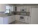 Bright kitchen with white cabinets, appliances, and tile floors at 820 Coconut Rd, Venice, FL 34293