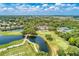 An aerial view showcasing a golf course, pond, and lush greenery enhancing its scenic charm at 8556 54Th Avenue E Cir, Bradenton, FL 34211