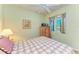 Comfortable bedroom featuring a plaid bedspread, wooden dresser, ceiling fan, and a window with a view at 8556 54Th Avenue E Cir, Bradenton, FL 34211