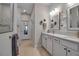 Bright bathroom featuring a double vanity, white cabinetry, modern fixtures, and tiled flooring at 8726 Backshore Ln, Parrish, FL 34219