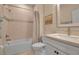 Cozy bathroom with tiled shower-tub, single sink vanity, framed mirror, and neutral color palette at 8726 Backshore Ln, Parrish, FL 34219