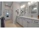 Bright bathroom featuring a double vanity, white cabinetry, modern fixtures, and tiled flooring at 8726 Backshore Ln, Parrish, FL 34219