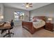 Comfortable bedroom with scenic view, featuring a wooden bed frame, ceiling fan and wood-style tile flooring at 8726 Backshore Ln, Parrish, FL 34219