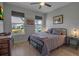 Comfortable bedroom with views to the yard, featuring a metal bed frame, windows and wood-style tile flooring at 8726 Backshore Ln, Parrish, FL 34219