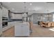 Bright, open kitchen features stainless appliances, white cabinets, backsplash, and a large island with bar seating at 8726 Backshore Ln, Parrish, FL 34219