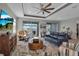 Open living area with a ceiling fan, comfortable seating, and expansive windows offering beautiful waterfront views at 8726 Backshore Ln, Parrish, FL 34219
