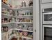 Well-organized pantry with shelving provides ample storage adjacent to stainless steel double oven at 8726 Backshore Ln, Parrish, FL 34219