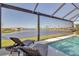 Enclosed pool featuring lounge chairs and lake views at 8726 Backshore Ln, Parrish, FL 34219