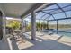 Enclosed lanai area boasts a pool, spa, table with chairs, and seating with lush landscaping at 8726 Backshore Ln, Parrish, FL 34219
