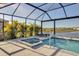 Enclosed pool features a spa with lush landscaping, chaise lounges, and lake views at 8726 Backshore Ln, Parrish, FL 34219