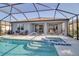Enclosed lanai features a pool, spa, and outdoor seating with lake views at 8726 Backshore Ln, Parrish, FL 34219