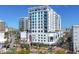 Modern condo building displaying its sleek white facade, private balconies, and vibrant surroundings with palm tree landscaping at 111 S Pineapple Ave # 804, Sarasota, FL 34236
