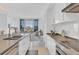 Modern condo kitchen featuring white cabinets, stainless appliances, and a view to the living area at 111 S Pineapple Ave # 804, Sarasota, FL 34236