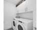 Well-lit laundry room featuring a washer and dryer, white cabinets, and storage baskets at 111 S Pineapple Ave # 804, Sarasota, FL 34236