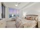 Bright, modern bedroom with ceiling fan, large window view, desk, and neutral, contemporary decor at 111 S Pineapple Ave # 804, Sarasota, FL 34236