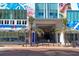 Street-level exterior showcasing palm trees, exterior art, and access to retail and banking amenities within the condominium building at 111 S Pineapple Ave # 804, Sarasota, FL 34236