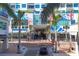 Street-level view of condo entrance, highlighted by palm trees, artistic exterior elements and convenient urban access at 111 S Pineapple Ave # 804, Sarasota, FL 34236