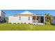 Rear exterior view of the light-blue single-story house, showing a screened lanai and a green lawn at 11371 Perico Isle Cir, Bradenton, FL 34209