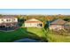 A backyard view showcases the home's screen enclosed lanai and landscaped yard, backing onto a serene pond at 11371 Perico Isle Cir, Bradenton, FL 34209