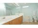 Well-lit bathroom features double sinks, a bathtub, shower, and a large mirror for added convenience at 11371 Perico Isle Cir, Bradenton, FL 34209