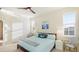 Bright bedroom featuring a queen bed, coastal-themed decor, plantation shutters, and a modern ceiling fan at 11371 Perico Isle Cir, Bradenton, FL 34209