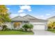 Beautiful home featuring a manicured lawn, lush landscaping, and a classic two-car garage at 11371 Perico Isle Cir, Bradenton, FL 34209