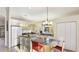 Sunlit kitchen featuring light wood cabinets, granite countertops, and a cozy breakfast bar with two chairs at 11371 Perico Isle Cir, Bradenton, FL 34209