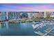 Stunning aerial view showcases waterfront condos, a marina, and the vibrant city skyline at sunset at 1155 N Gulfstream Ave # 1205, Sarasota, FL 34236